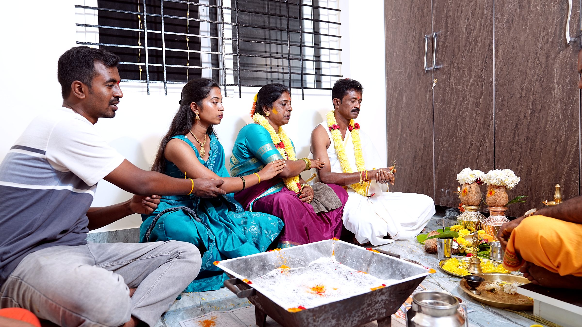 Couple performing the housewarming ritual with a priest