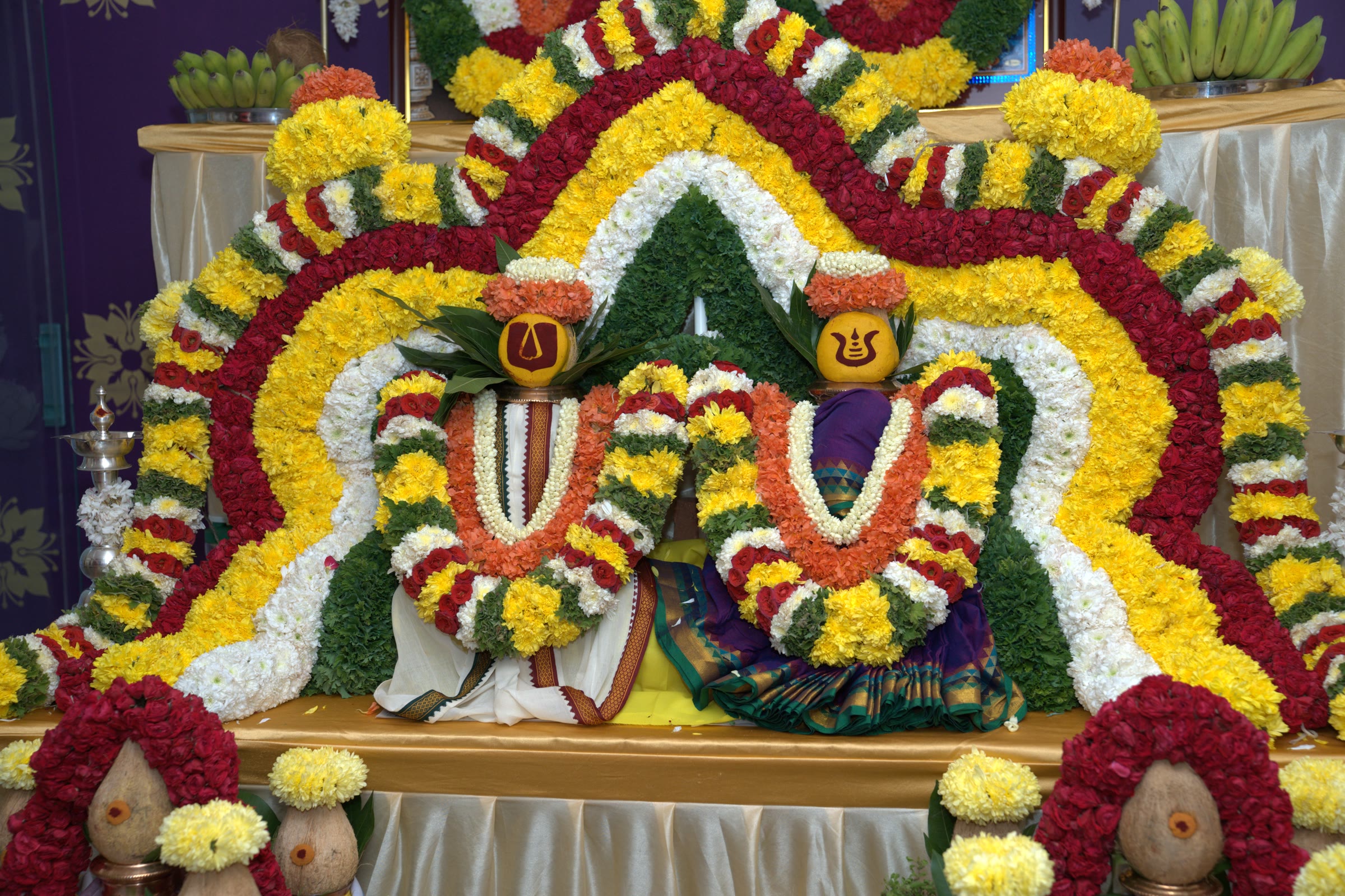 Deity photographs and floral decoration at a Griha Pravesha ceremony altar