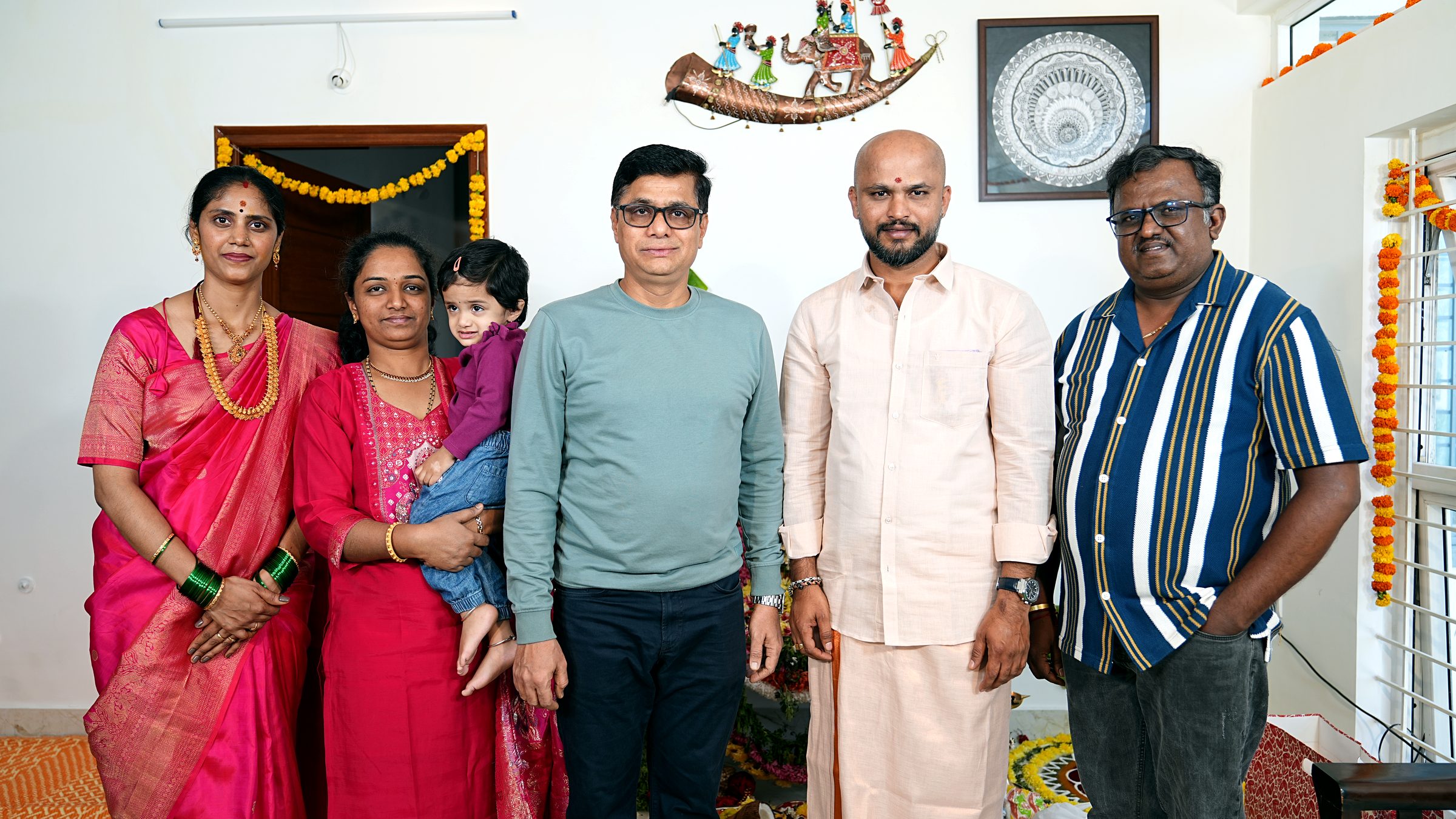 Family sharing a warm candid moment during the Griha Pravesha celebration